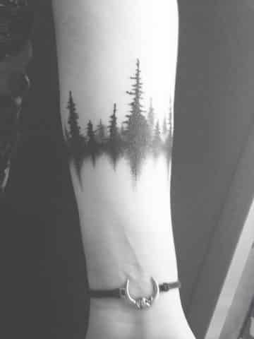 tatuajes de pinos en el brazo con reflejo