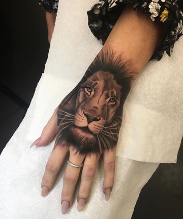 Diseños realistas de tatuajes de leones en la mano