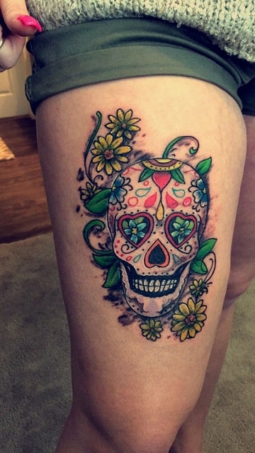 calaveras mexicanas con flores tatuaje en la pierna
