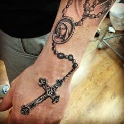 Diversos tatuajes de rosarios en el antebrazo