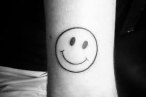 tatuajes de caritas felices en el brazo