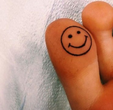 tatuajes de caritas felices en el pie