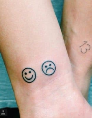 tatuajes de caritas tristes y alegres en la pierna