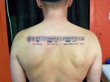 tatuajes de pentagramas musicales en espalda de hombres
