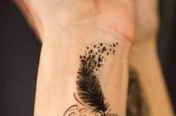 Delicados y sutiles tatuajes de plumas en la muñeca