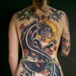 Grandiosos y definidos tatuajes de panteras en la espalda