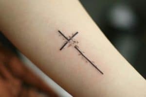 delicados tatuajes de cruces en el brazo
