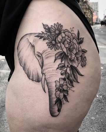 tatuajes de elefantes con flores en la pierna