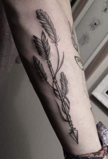tatuajes de flechas y plumas en el brazo