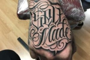 tatuajes de letras en la mano en el dorso