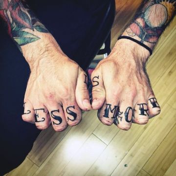 tatuajes de letras en la mano en los nudillos