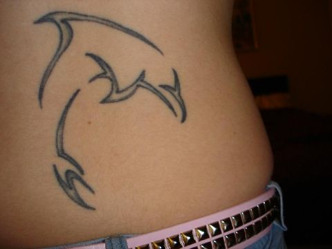 tatuajes de delfines en la cadera tribal