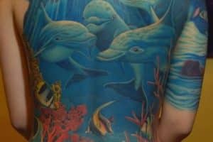 tatuajes de delfines en la espalda paisaje maritimo