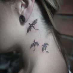 3 pequeños tatuajes de dragones en el cuello y grandes obras
