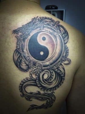 tatuajes de yin yang con dragon en omoplatos