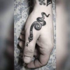 Un delicado tatuaje de serpiente en el dedo 3 posiciones