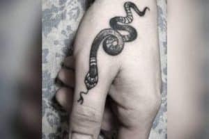 tatuaje de serpiente en el dedo pulgar
