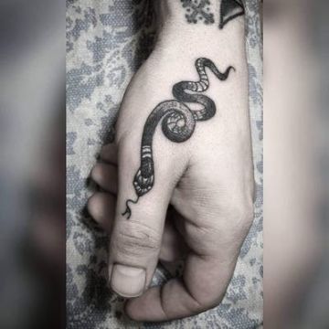 tatuaje de serpiente en el dedo pulgar