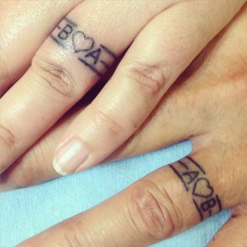 tatuajes de corazon con iniciales en dedos