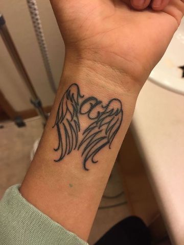 tatuajes de alas en la muñeca lineas con iniciales