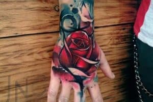 tatuajes de flores rojas en la mano