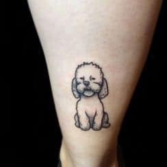 4 pequeños tatuajes de perritos caniches en el brazo