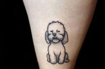 4 pequeños tatuajes de perritos caniches en el brazo