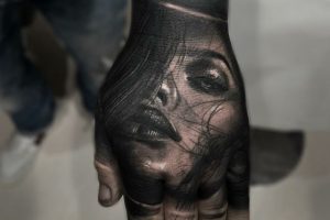 tatuajes de rostros humanos en la mano