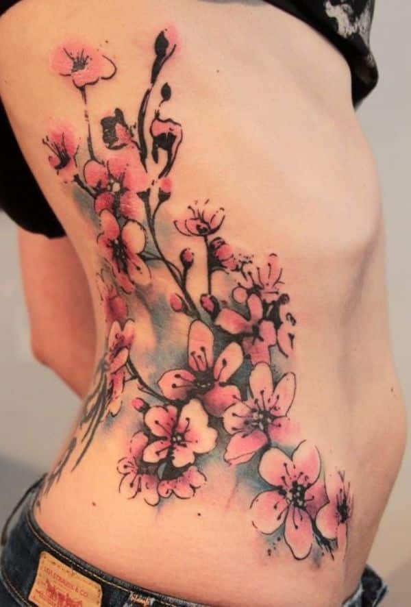 tatuajes de flor de sakura en costillas