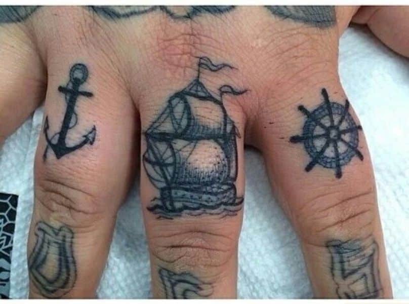 tatuaje de brujula y barco para los dedos