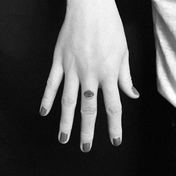 tatuaje de ojo turco minimalista en el dedo