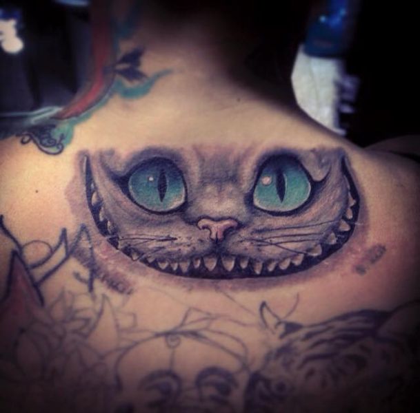 tatuajes de gato de alicia en espalda