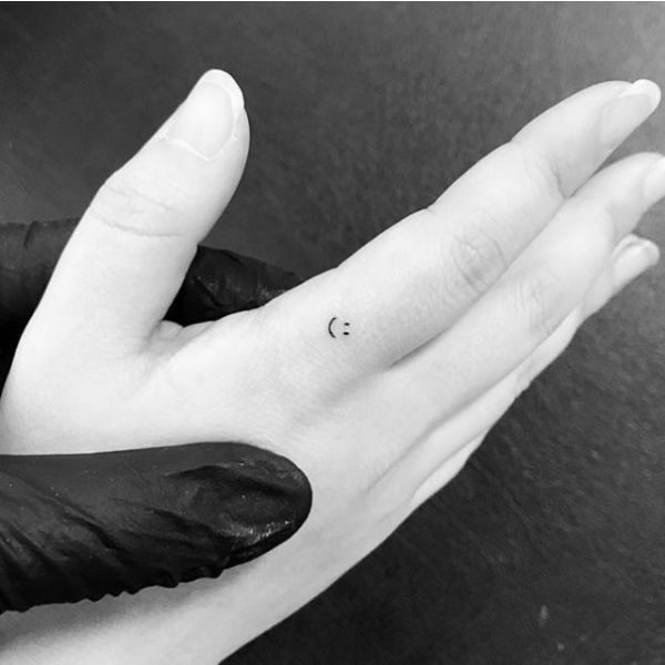 tatuaje sonrisa en la mano pequeños